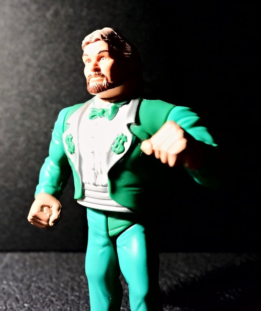 Ted DiBiase di fronte, con il volto girato di lato, nello smoking verde con i risvolti argento