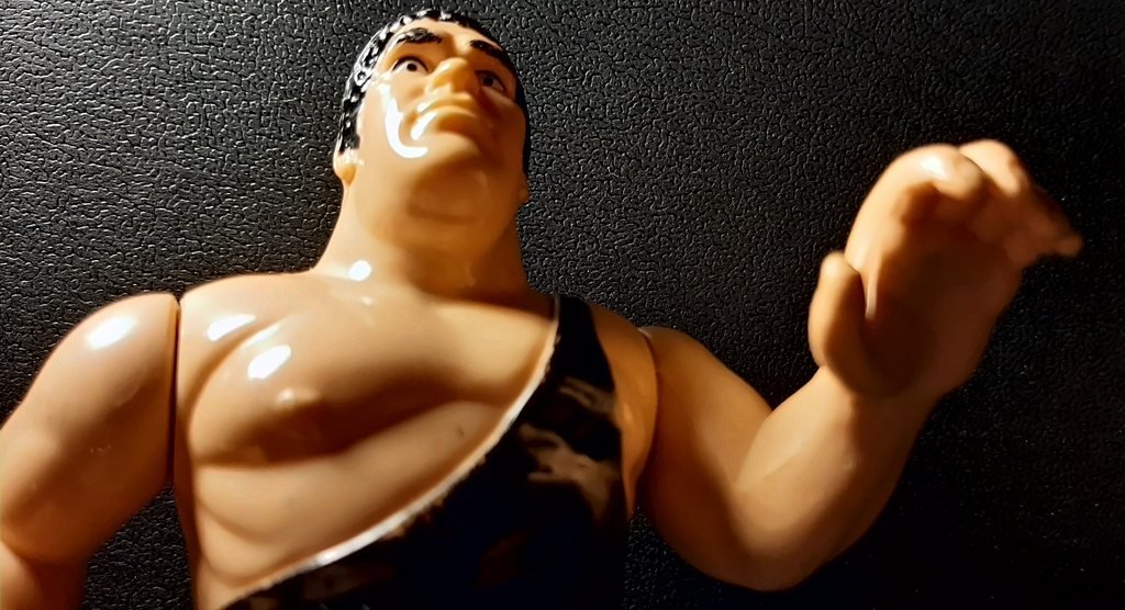 André the Giant visto dal basso, con la bretella del costume sulla spalla sinistra