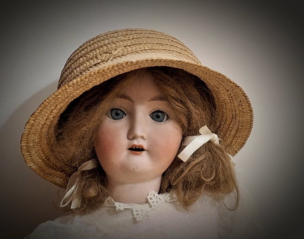 Il volto e il cappello di paglia, con i nastri bianchi fra i capelli