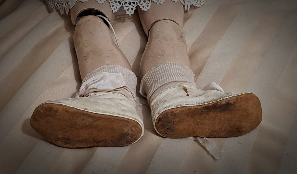 Le gambe snodate alle ginocchia, i calzini bianchi a coste e le suole consumate delle scarpe
