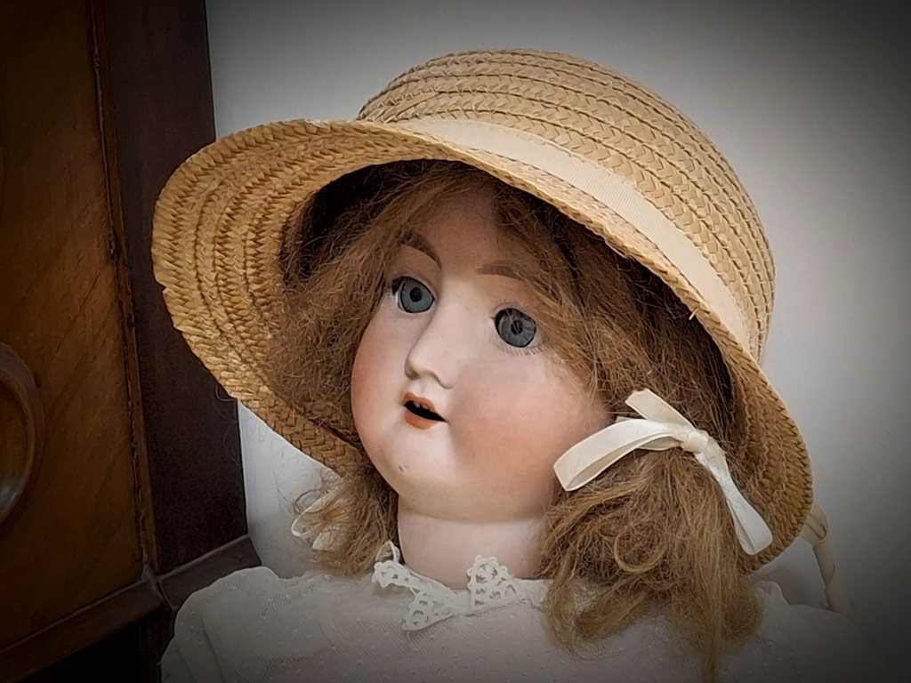 Il volto di tre quarti, girato verso la sua destra, sotto la falda del cappello di paglia