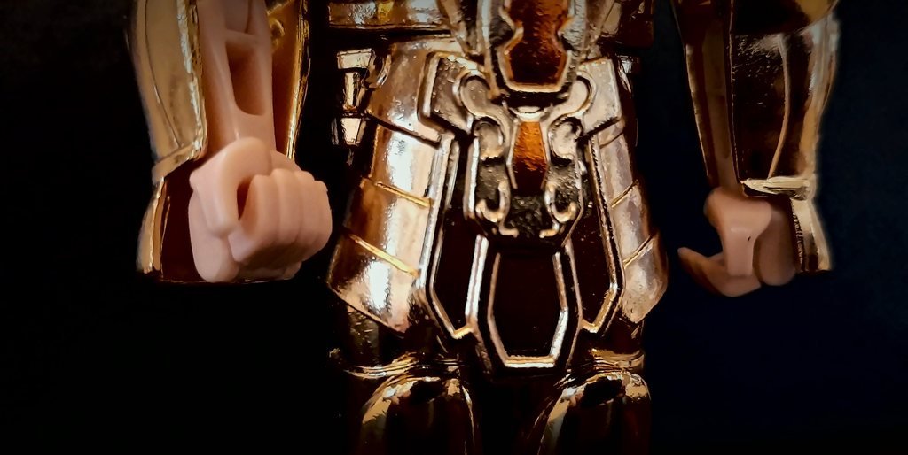 La cintura e la parte bassa del pettorale, con gli inserti arancio, fra i pugni color carne