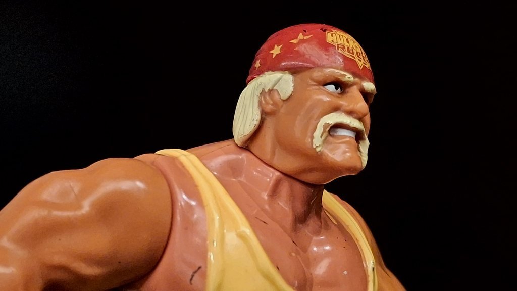 Hulk Hogan di profilo, con le stelle gialle sul lato destro della bandana e il braccio destro in primo piano