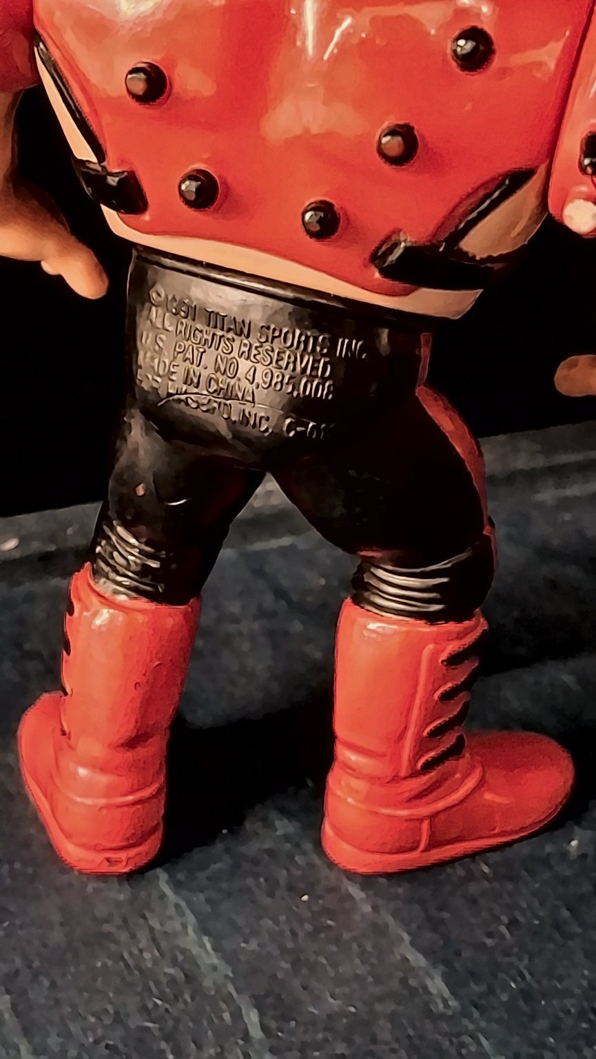 Le gambe di Animal viste da dietro, con le scritte in rilievo della Titan Sports e della Hasbro sul retro della calzamaglia