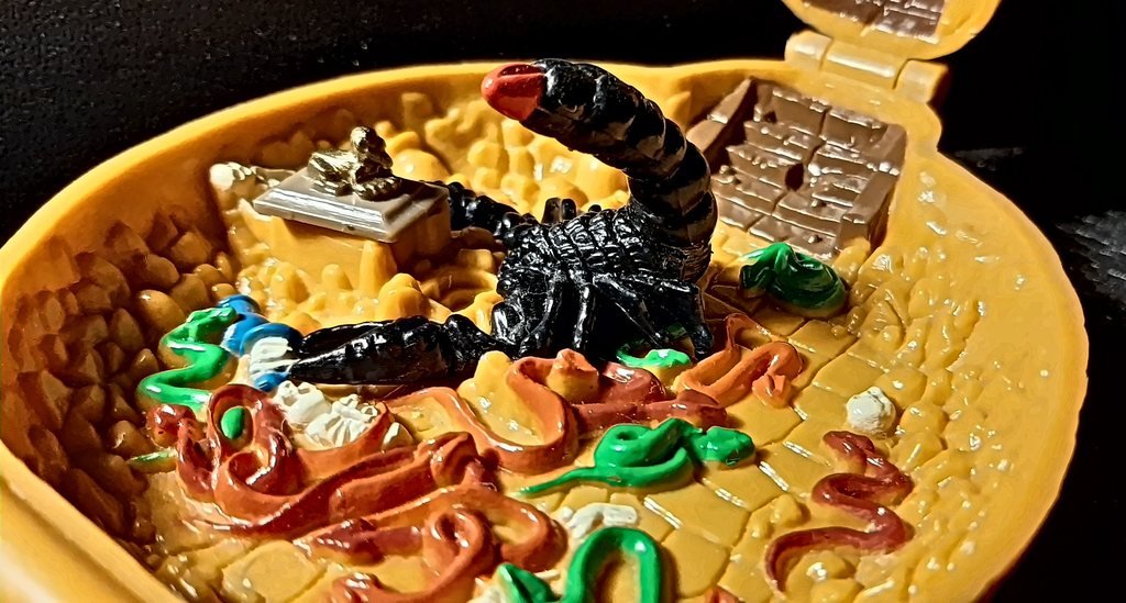 La base da vicino: lo scorpione nero sul tesoro, la tomba con la sfinge d'oro, i serpenti rossi e verdi fra i teschi